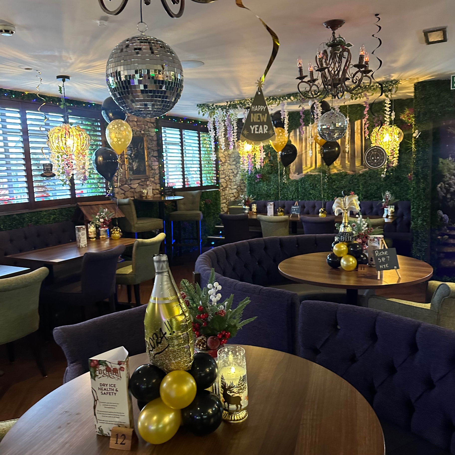 Tables set with balloons and mirror balls for New Year's Eve