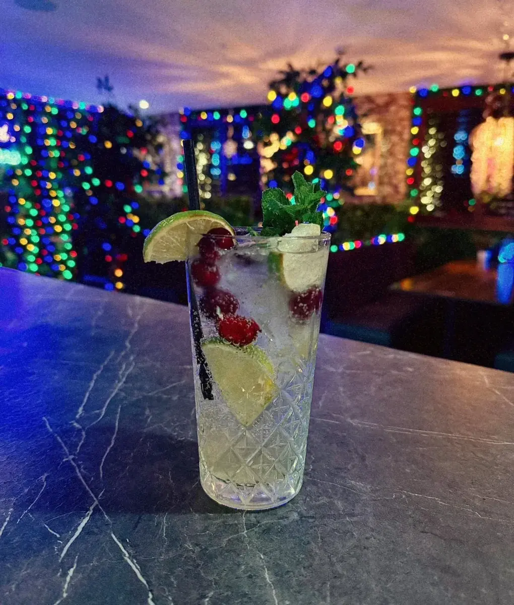 Cocktail in front of glowing fairy lights