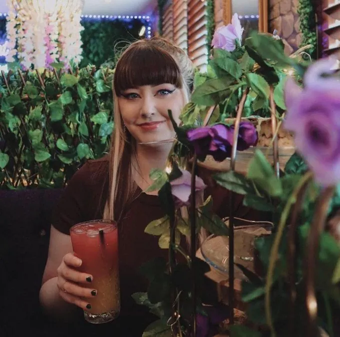 Guest holding a cocktail in the forest room