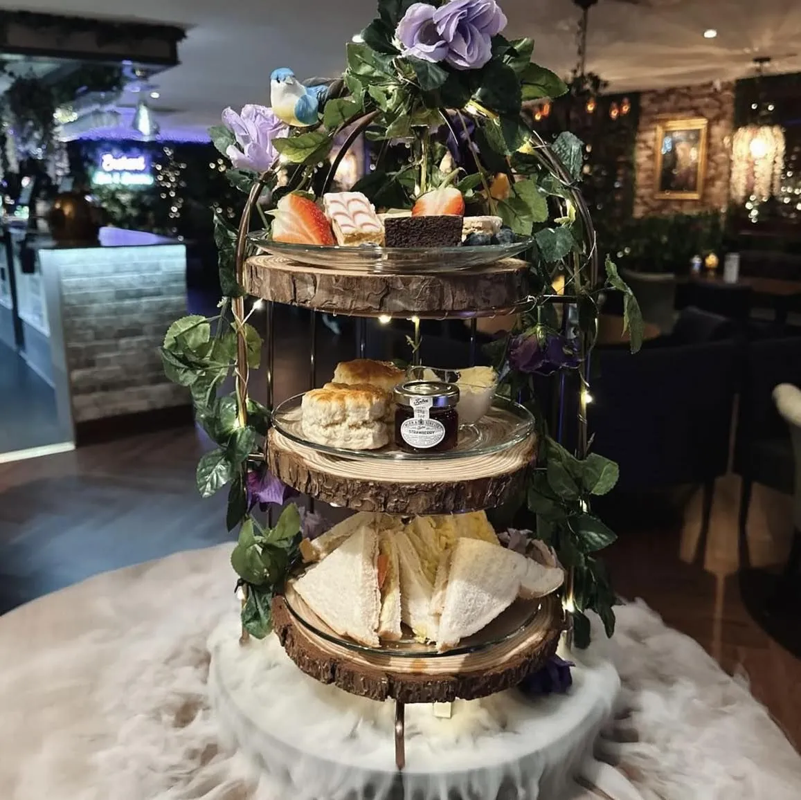 Afternoon tea tiered stand surrounded by flowers